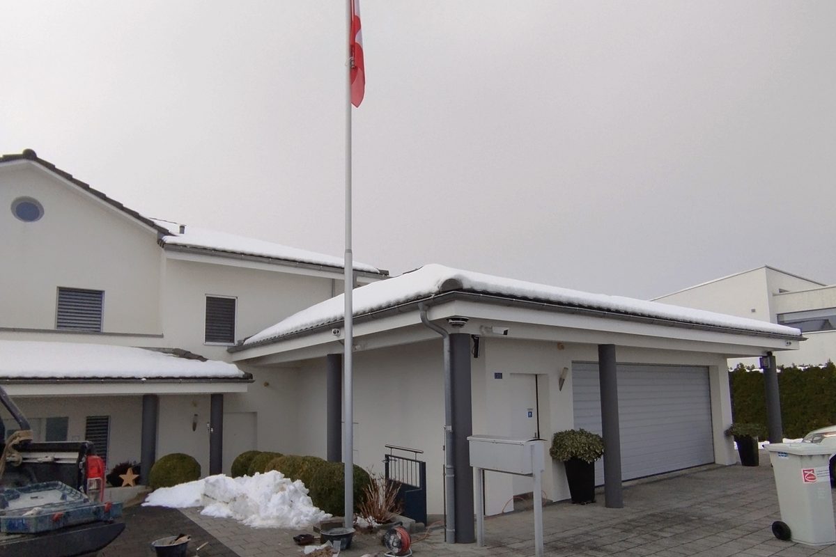 Fertig montierter Fahnenmast mit Schweizer Fahne vor dem Haus in Eich